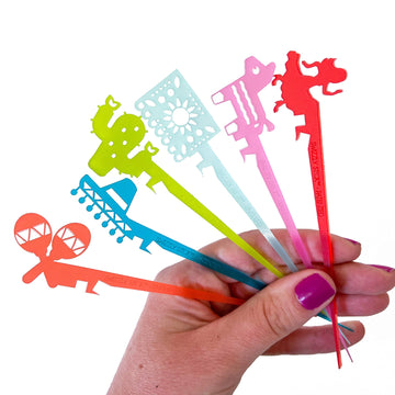 Fiesta themed cocktail pick Swizzly Sticks. Shapes include maracas, sombrero, cactus, Mexican bunting, piñata, and salsa dancer.